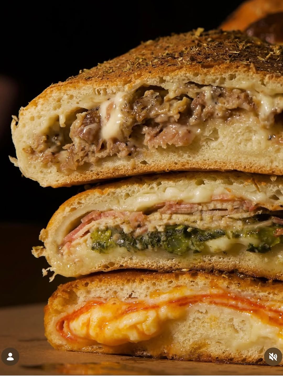 A stack of fresh-cut strombolis showing roast pork, pepperoni and cheese fillings